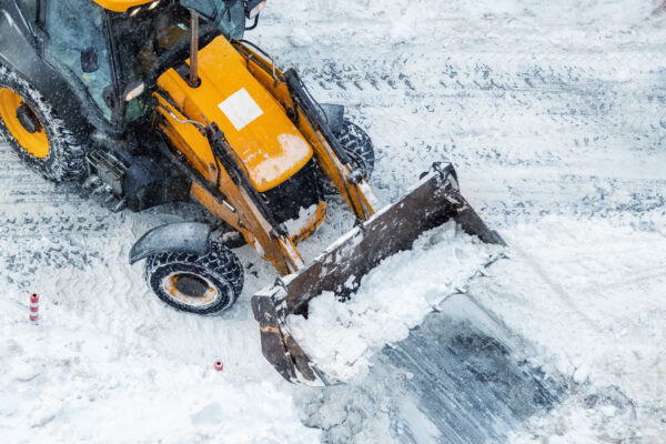 Spartan backhoe clearing snow from a commercial facility property