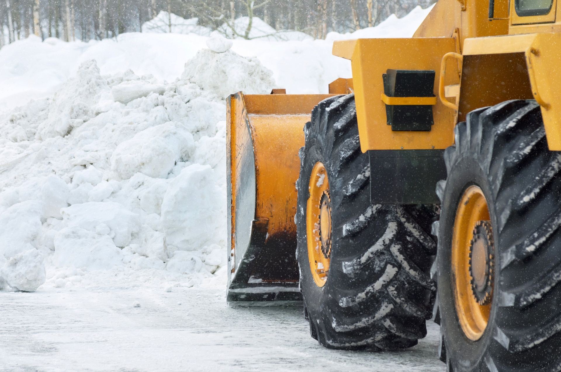 Spartan Snow Removal loader plowing a commercial parking lot